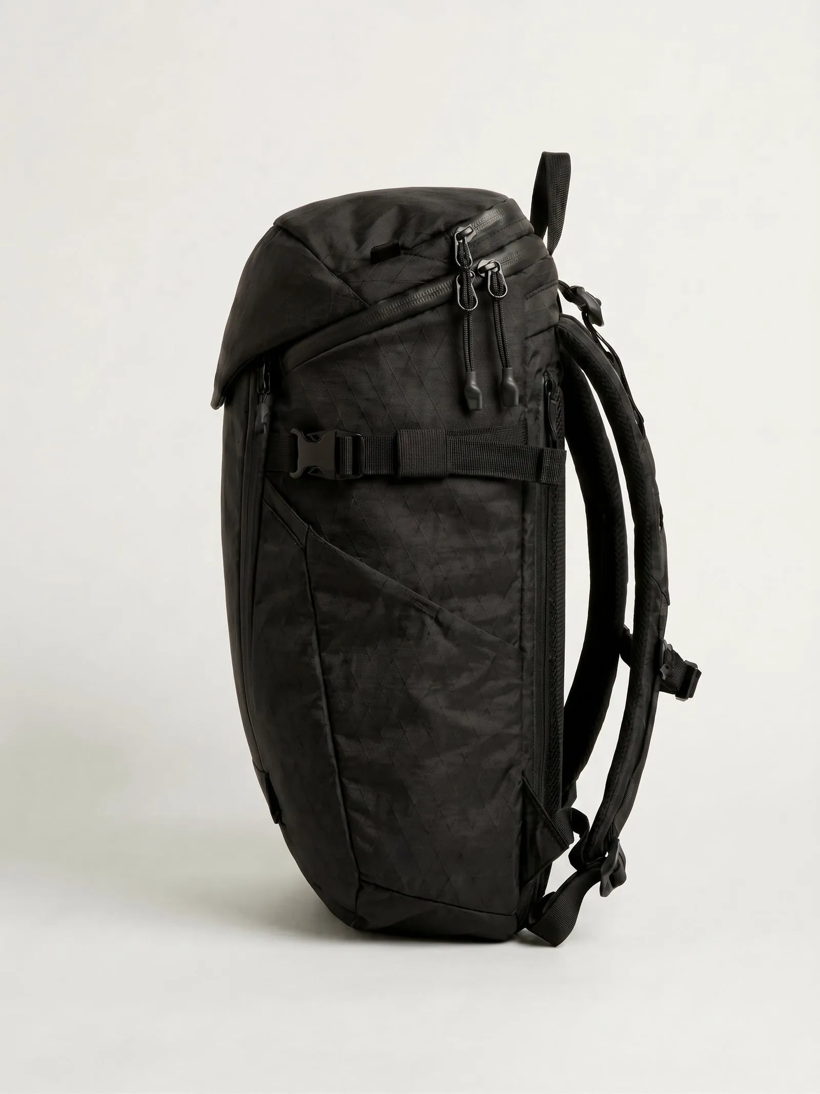 Official side view of the black Coywolf 28 showing the harness, side pocket, zipper access and compression strap.